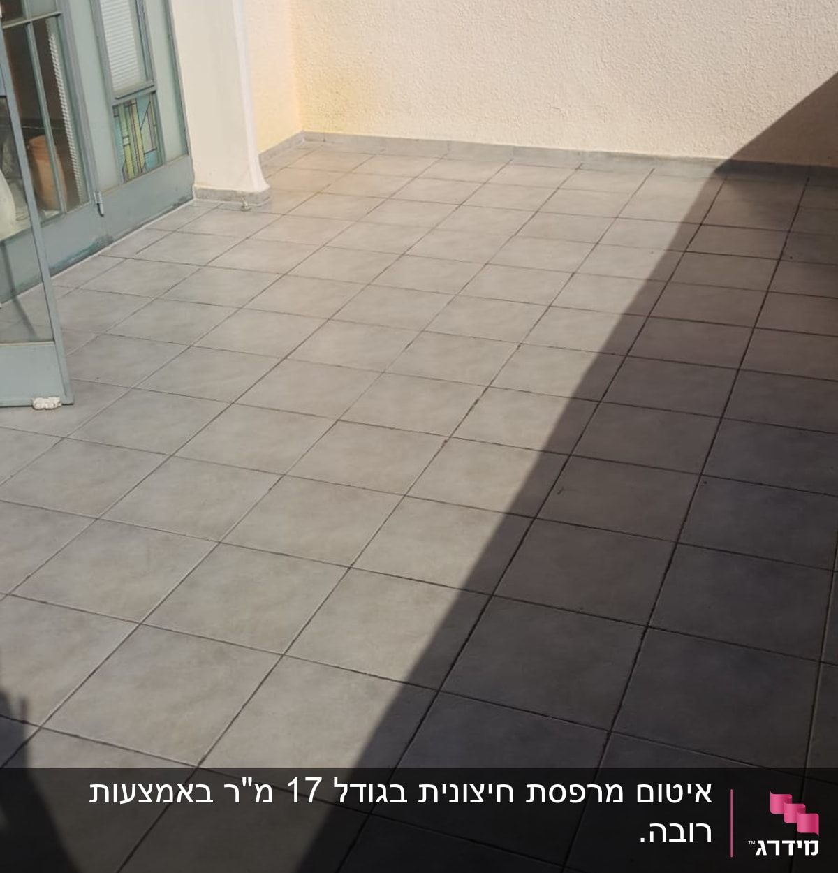 מרפסת מרוצפת עם דלת זכוכית פתוחה